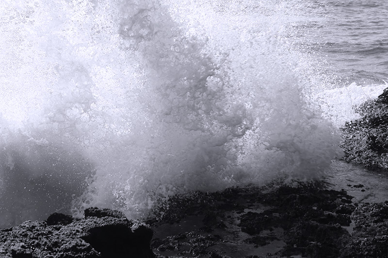 Photo of sea wave breaking on rocks